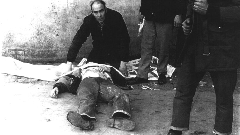 La drammatica immagine poi icona della Bloody Sunday: il corpo di Hugh Gilmour coperto con lo striscione della Derry Civil Rights Association (Fulvio Grimaldi, courtesy Museum of Free Derry)