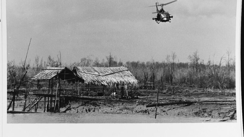 Il volo di uno Huey su un villaggio bruciato (Us Navy)