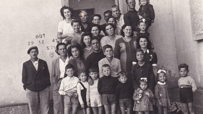 Famiglia di coloni a Fertilia. Sul muro, la scritta che indica la disinfestazione con DDT nel 1947 (Courtesy Ecomuseo Egea)