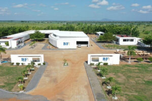 Veduta aerea del complesso moderno di BFuture Farm di BF in Ghana, composto da edifici bianchi e piazzali circondati da campi agricoli