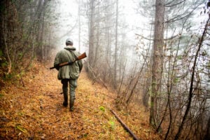 Cacciatore nel bosco durante la stagione venatoria