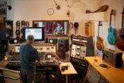 Musicista che suona la chitarra in uno studio di registrazione analogico