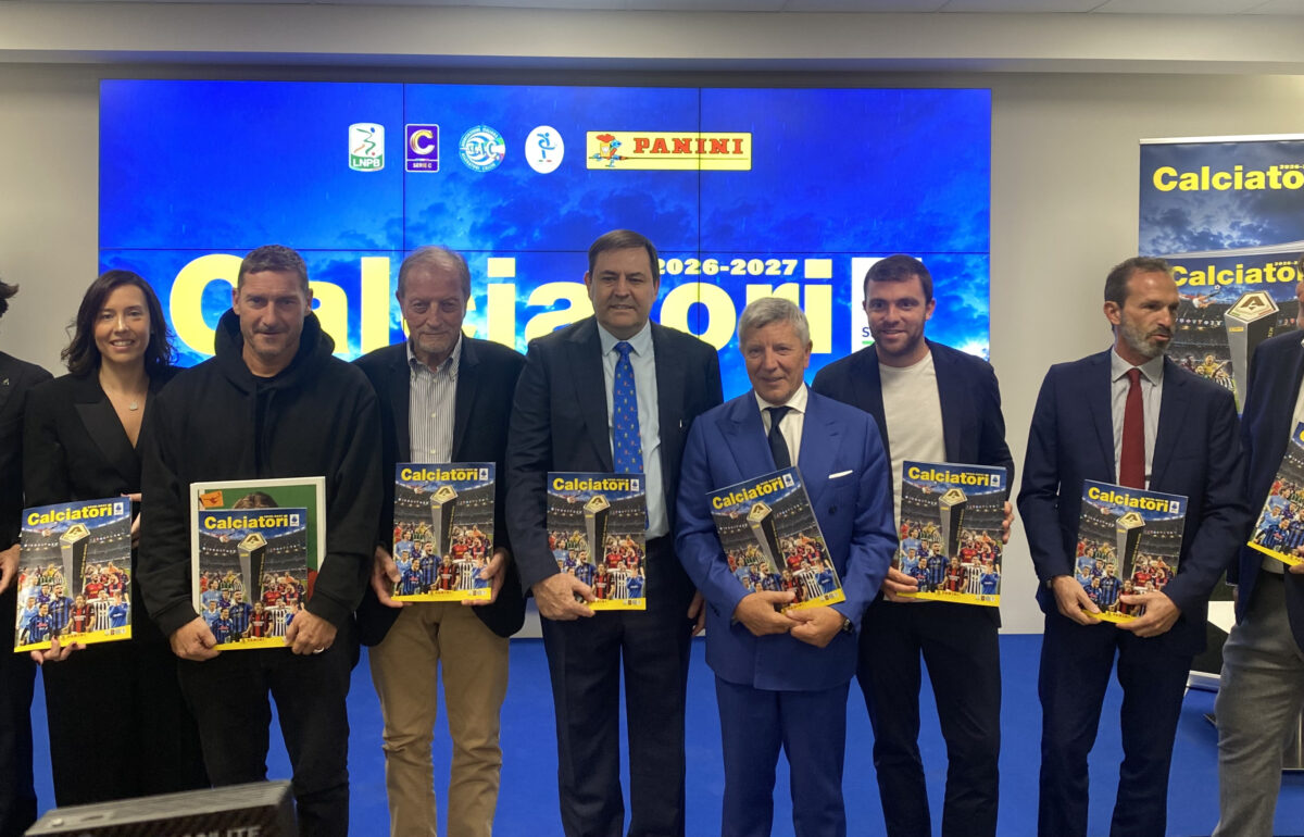 I rappresentanti di Panini e del calcio italiano in posa sul palco con le copie della nuova collezione dell'album Calciatori 2026-2027