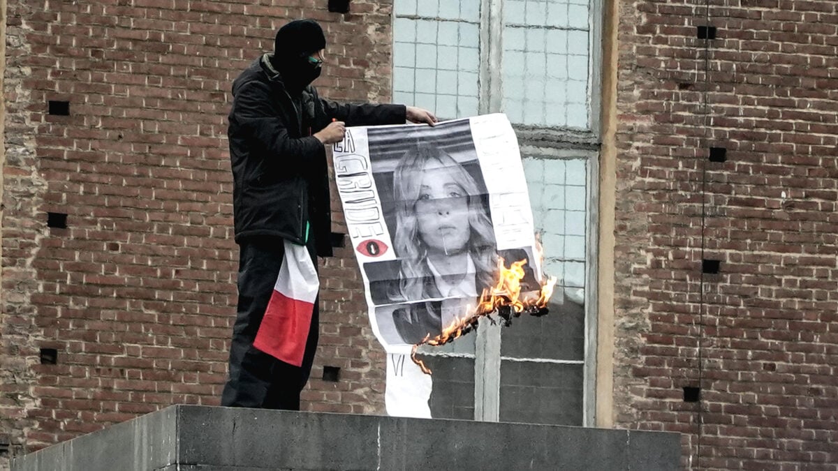 Manifestante brucia una fotografia di Giorgia Meloni durante il corteo a Torino del 24 ottobre 2026
