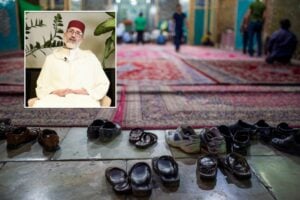 Scarpe all’ingresso di una moschea a Yazd, in Iran, con un riquadro dedicato a Moustapha Hajraoui, presidente della Confederazione islamica italiana