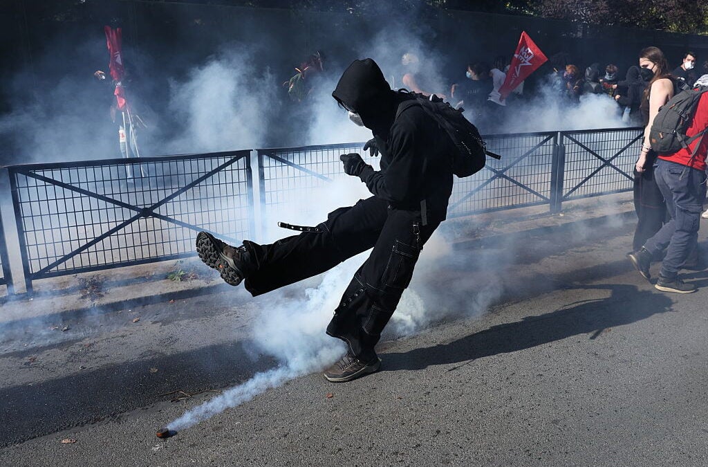 Studente calcia una bomboletta di gas lacrimogeno durante le proteste in Francia