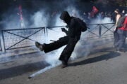 Studente calcia una bomboletta di gas lacrimogeno durante le proteste in Francia