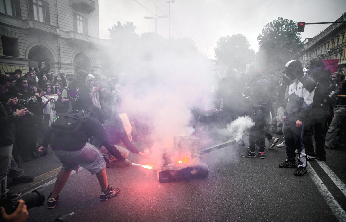 Manifestanti bruciano un carro armato di cartone durante il corteo studentesco a Torino il 16 ottobre 2026