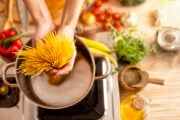 Donna in cucina mentre prepara gli spaghetti