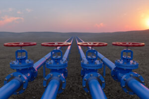 Dettaglio di tubature industriali metalliche e valvole blu per la regolazione e il trasporto di gas e idrocarburi